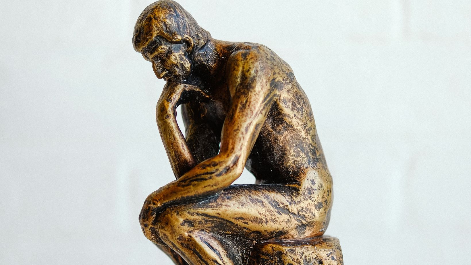 Escultura de un pensador sentado, símbolo de reflexión sobre el protocolo institucional